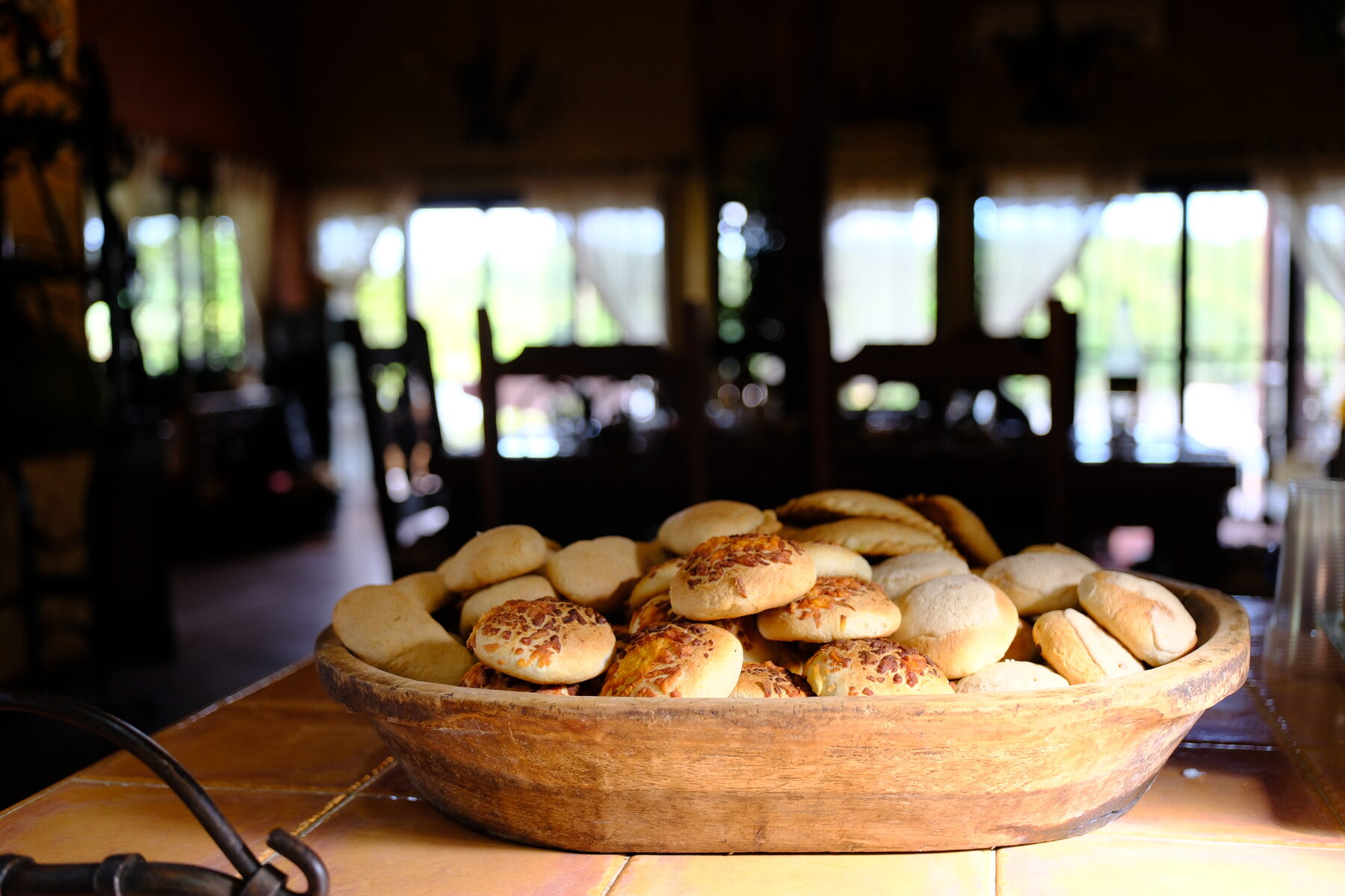A wooden bowl of bread, warm low light