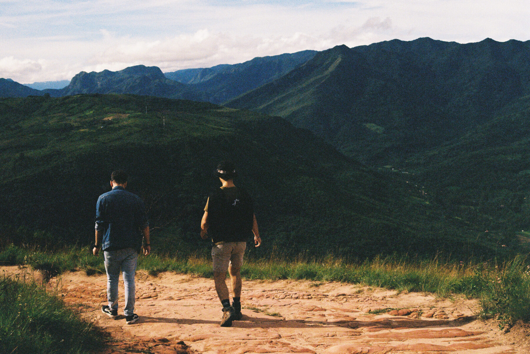 Two guests walking a trail into the hills